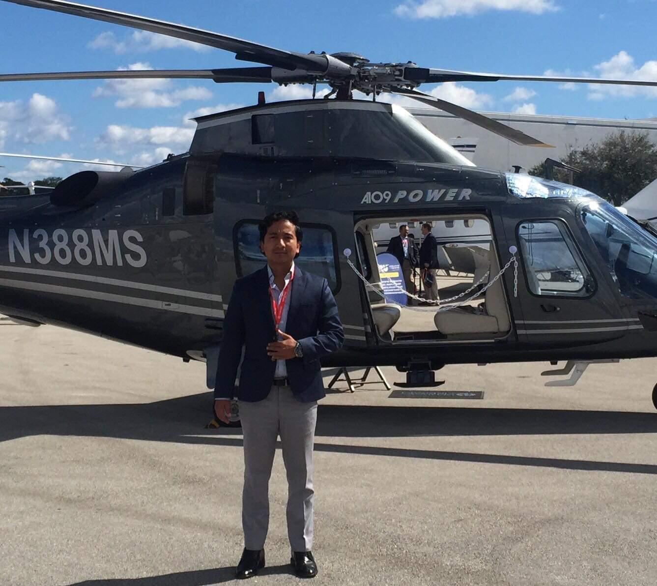 Abhinav Karki in front of an AW109 helicopter